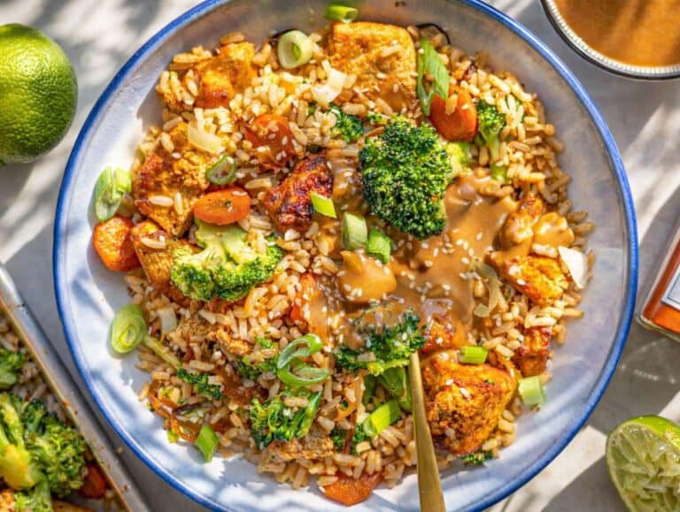 Step 5 Tofu rice bowl with broccoli and peanut butter sauce served with spoon.