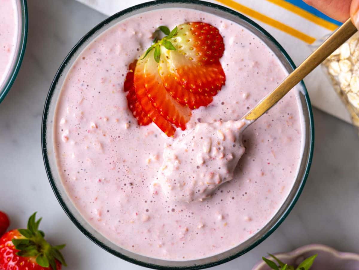 Strawberry overnight oats with Greek yogurt in a bowl with spoon.