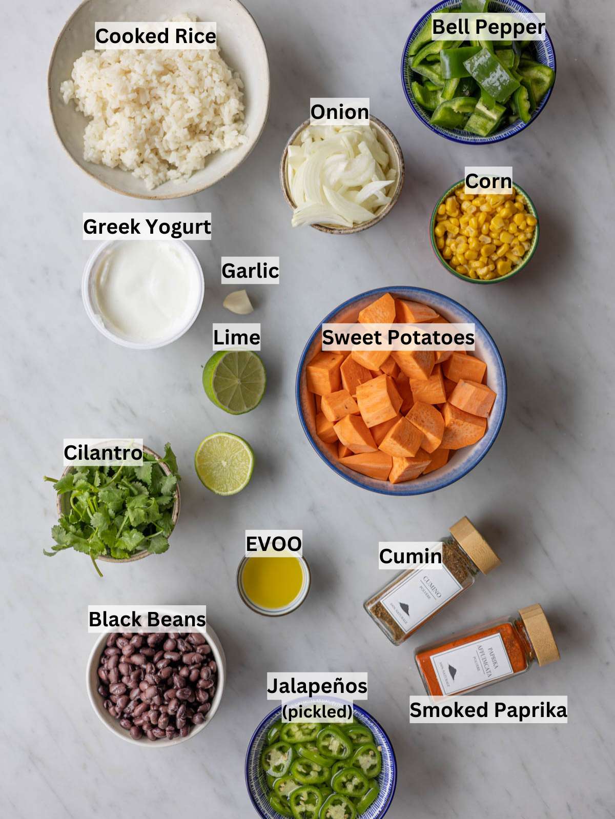 Sweet potatoes, black beans, rice, yogurt, cilantro, lime, and spices arranged on counter.