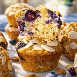 Almond flour blueberry muffins with Greek yogurt stacked neatly under bright, natural light.