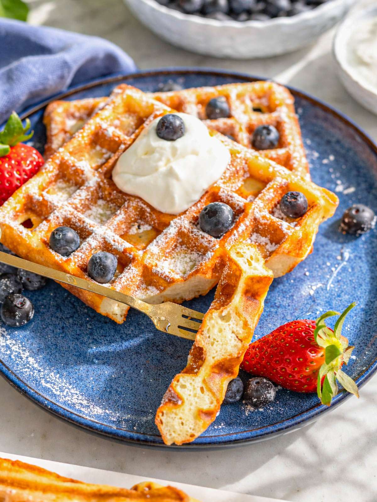Close up of Greek yogurt waffle showing crisp edges and soft interior texture.