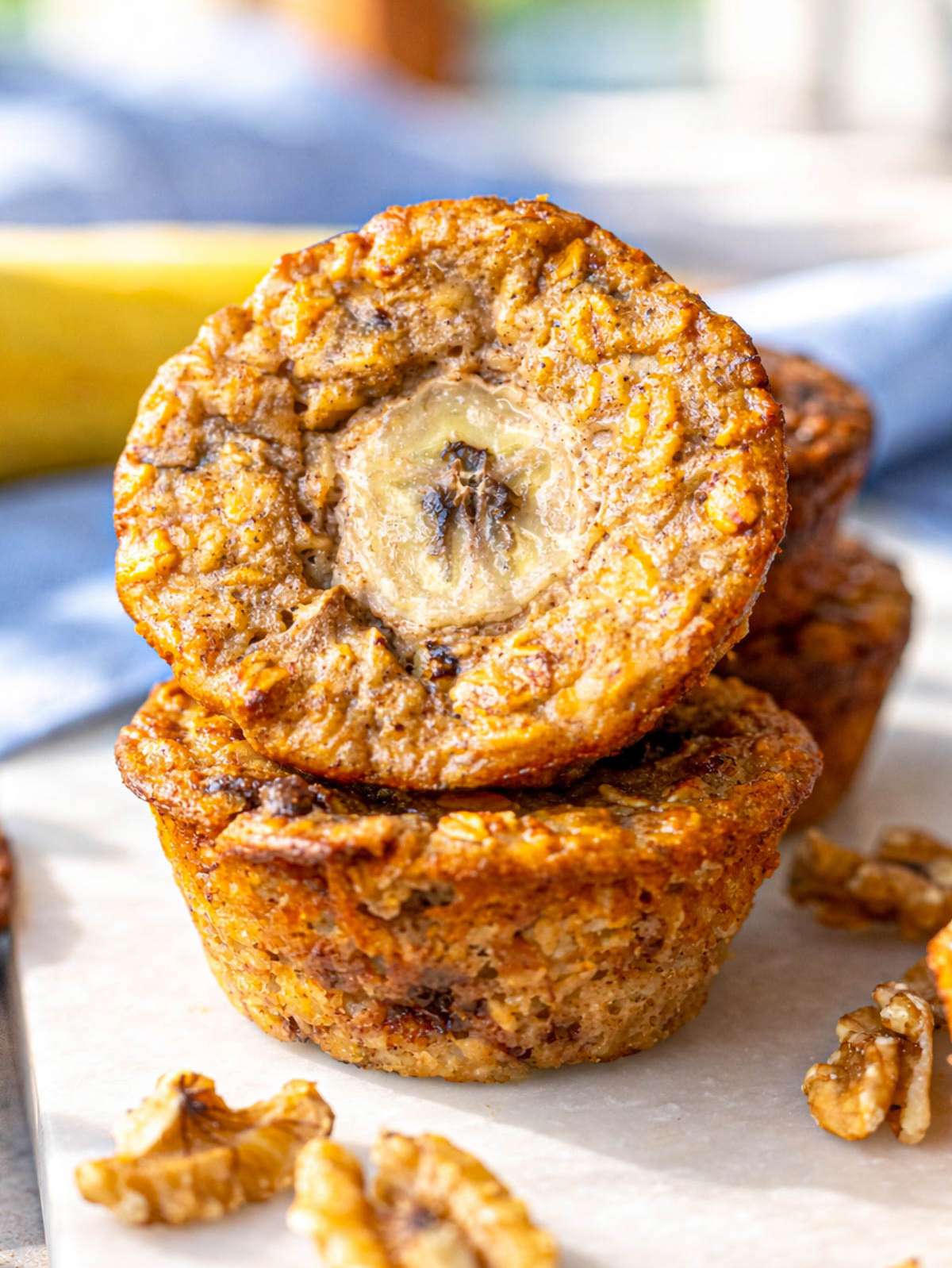 Close up of banana baked oatmeal cup showing soft oat texture with banana slice on top.