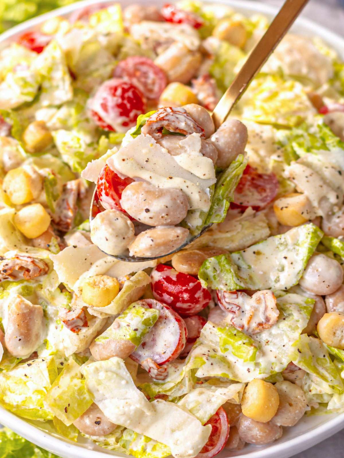 Close up of butter bean Caesar salad showing creamy dressing beans lettuce and croutons.