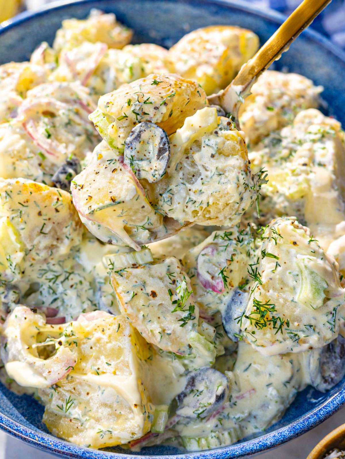 Close-up of creamy potato salad with yogurt dressing, capers, and fresh dill.