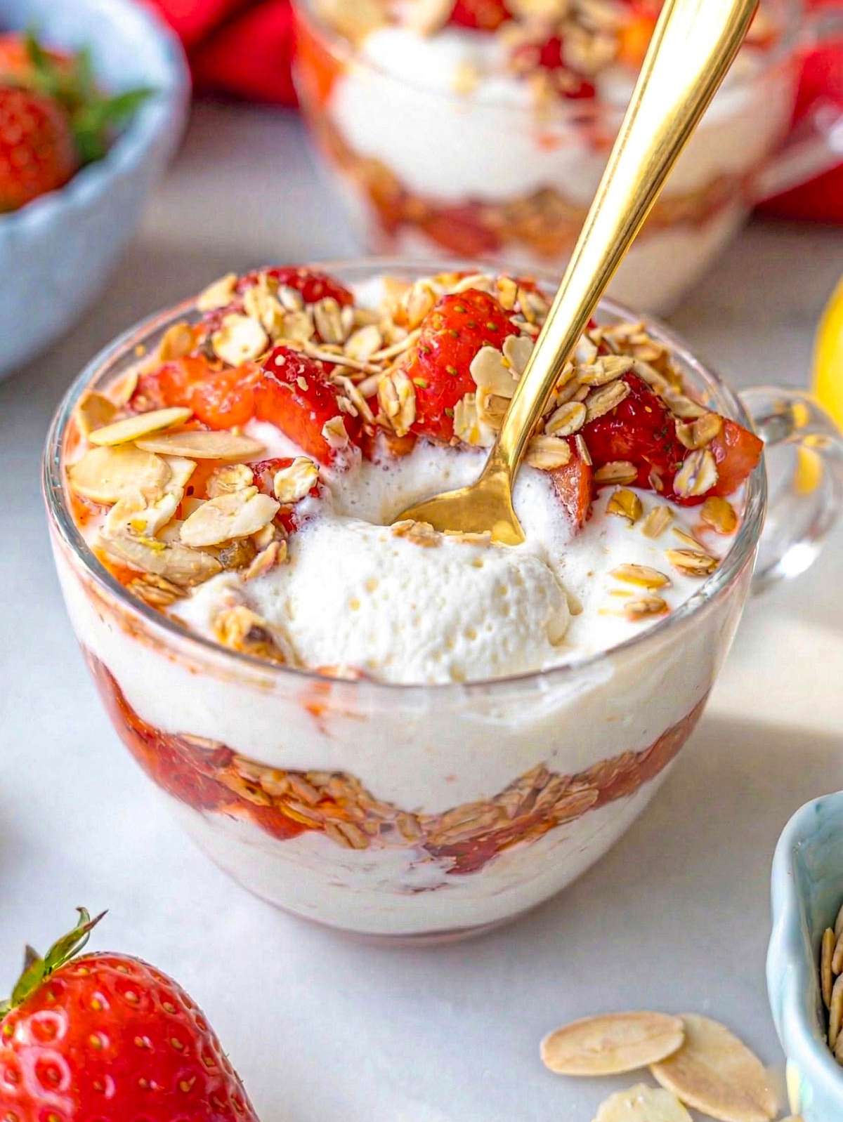 Close up of creamy yogurt with strawberry syrup and toasted oats.