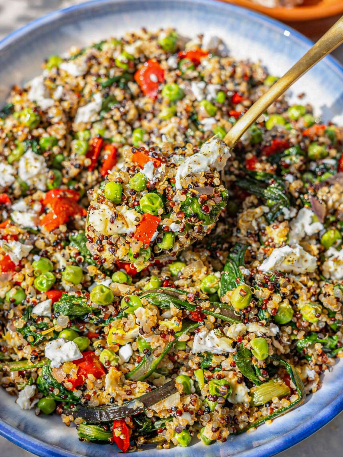 Close up of fluffy quinoa with soft scrambled eggs spinach and crumbled feta.