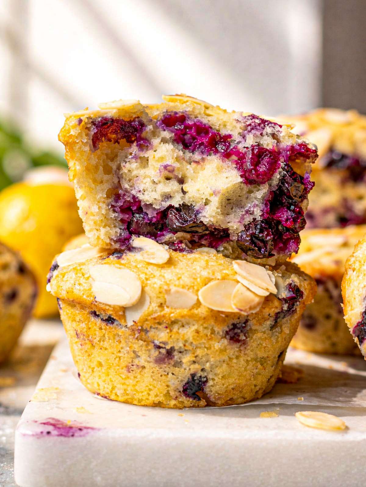 Close-up of lemon blueberry muffin showing moist crumb and juicy blueberries inside.