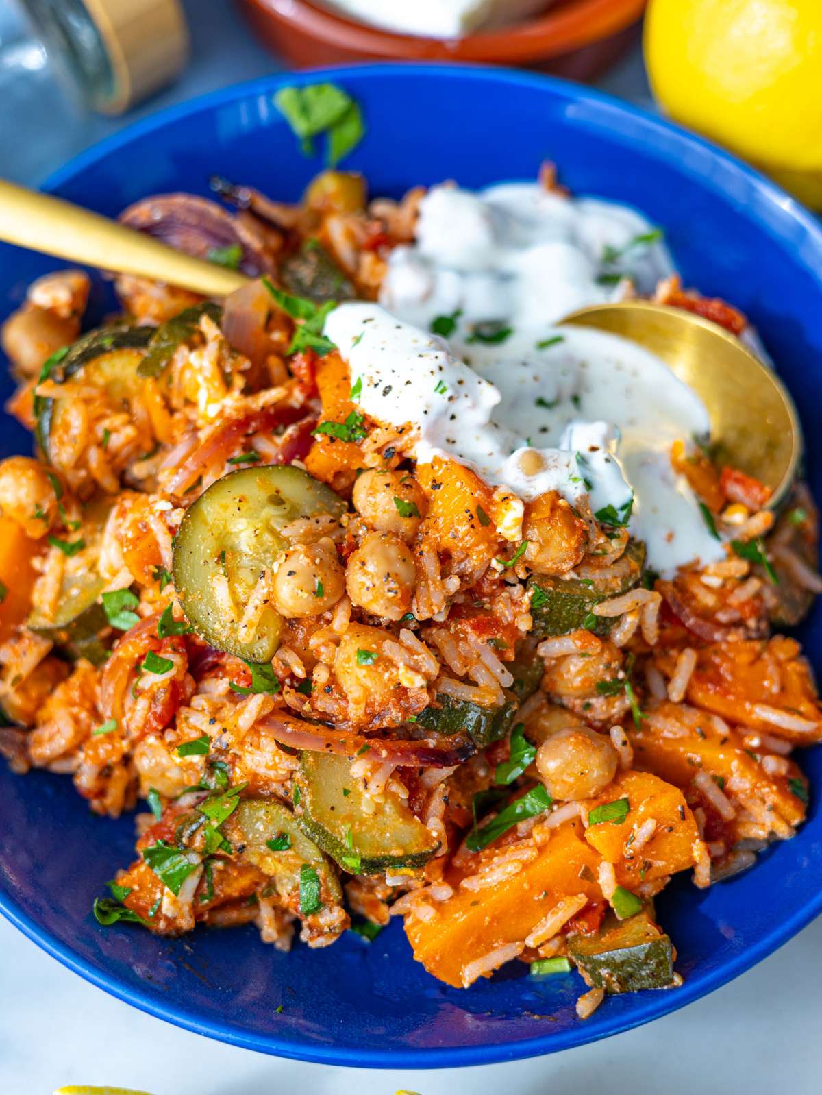 Close up of rice bowl with roasted vegetables and creamy yogurt swirl.