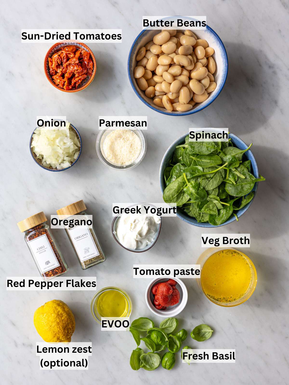 Fresh ingredients and canned butter beans arranged on a bright marble surface in natural light.