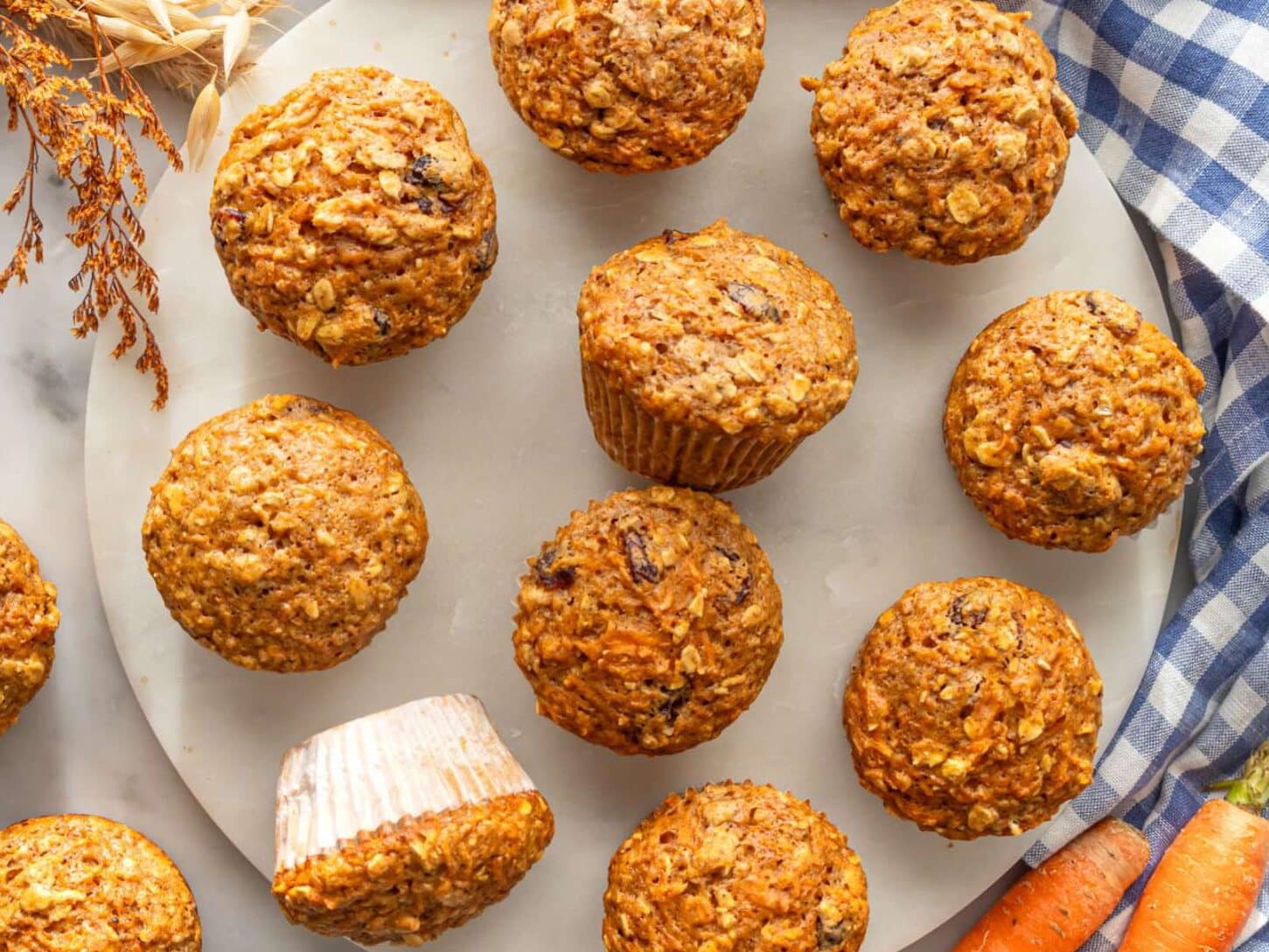 Freshly baked oil free carrot muffins displayed on a marble table for wholesome morning treat.
