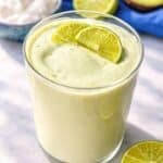 Glass of Greek yogurt avocado smoothie on marble table with soft natural light.