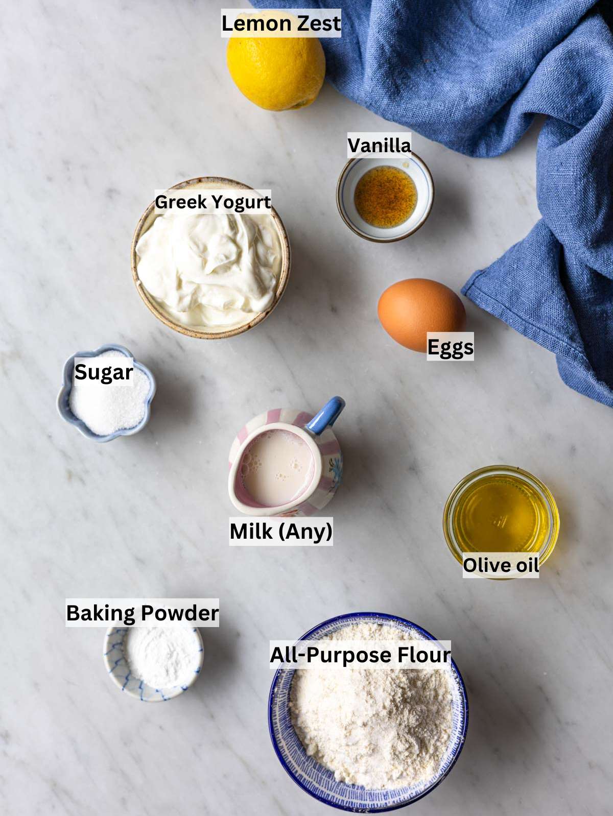 Ingredients for Greek yogurt waffles arranged on marble surface in soft natural window light.