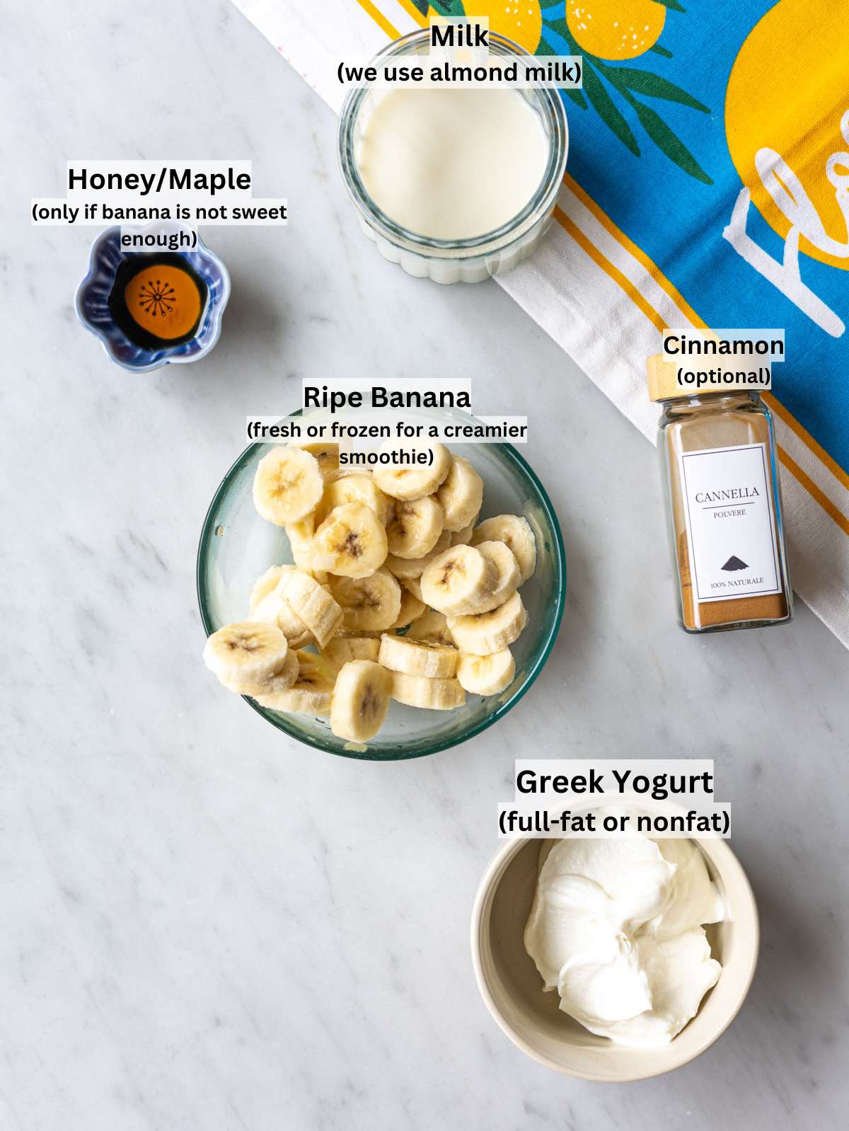 Ripe bananas, Greek yogurt, almond milk, and honey on marble table in natural light.