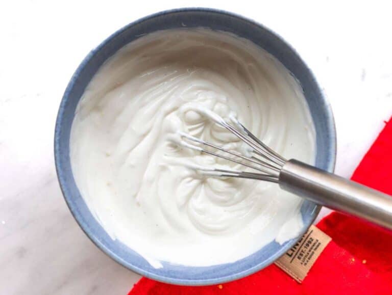 Step 1 Mixing Greek yogurt with lemon zest and honey in bowl on marble surface.