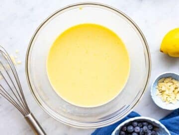 Step 1 Mixing egg, yogurt, and lemon in bowl on marble surface in natural window light.