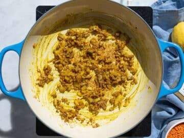 Step 1 Sautéed onions and fragrant spices softening in a large pot on the stove.