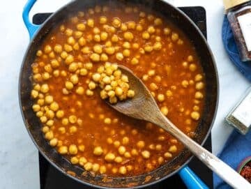 Step 2 Chickpeas and savory broth simmering gently in a wide pan under bright natural light.