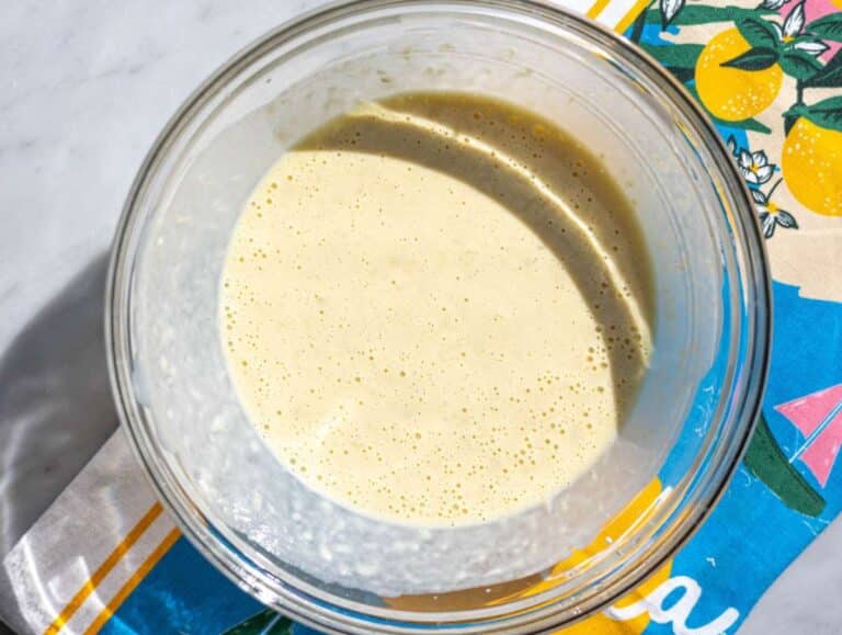 Step 2 Mashed banana mixed with yogurt, egg, and milk in a glass bowl.