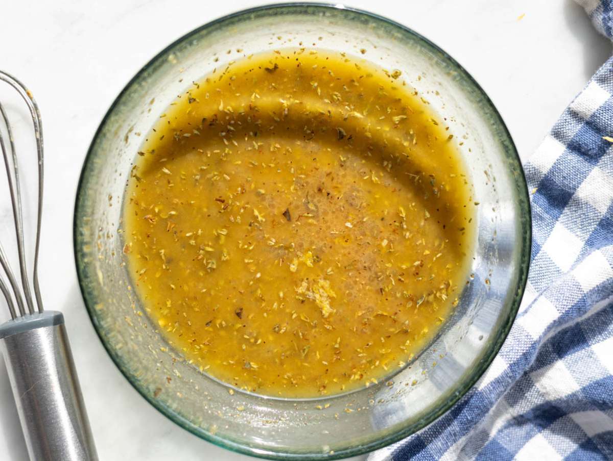 Step 2 Olive oil vinegar mustard oregano and garlic whisked together in a small bowl.