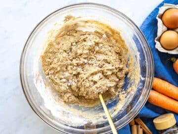 Step 2 Stirring thick carrot cake batter with flour and spices in large bowl.