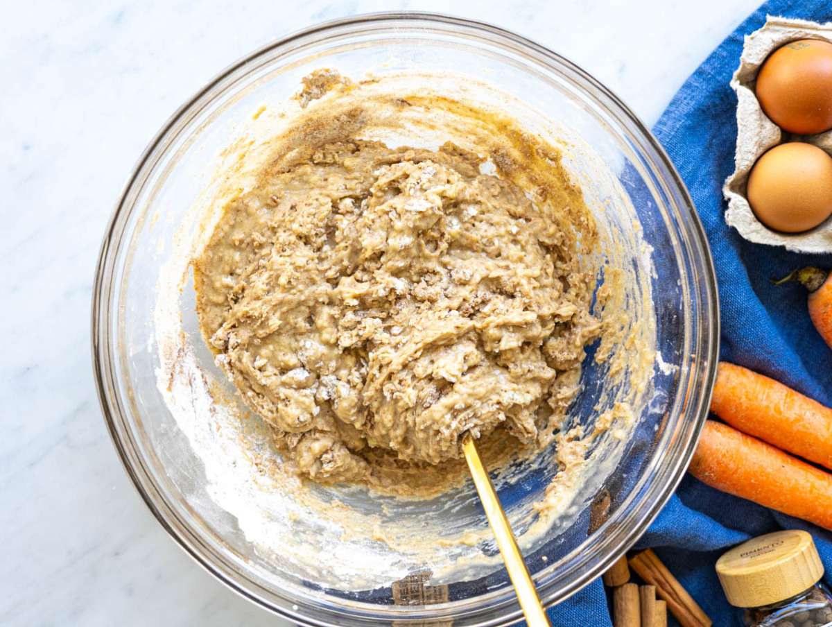 Step 2 Stirring thick carrot cake batter with flour and spices in large bowl.