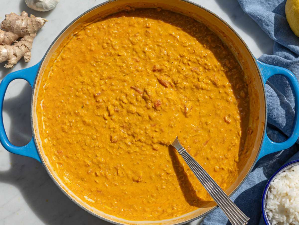 Step 3 A spoon stirring thick Greek yogurt into the warm finished curry.