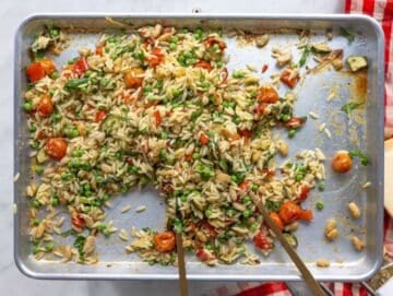 Step 3 Hot orzo added to roasted vegetables on sheet pan with parmesan sprinkled.