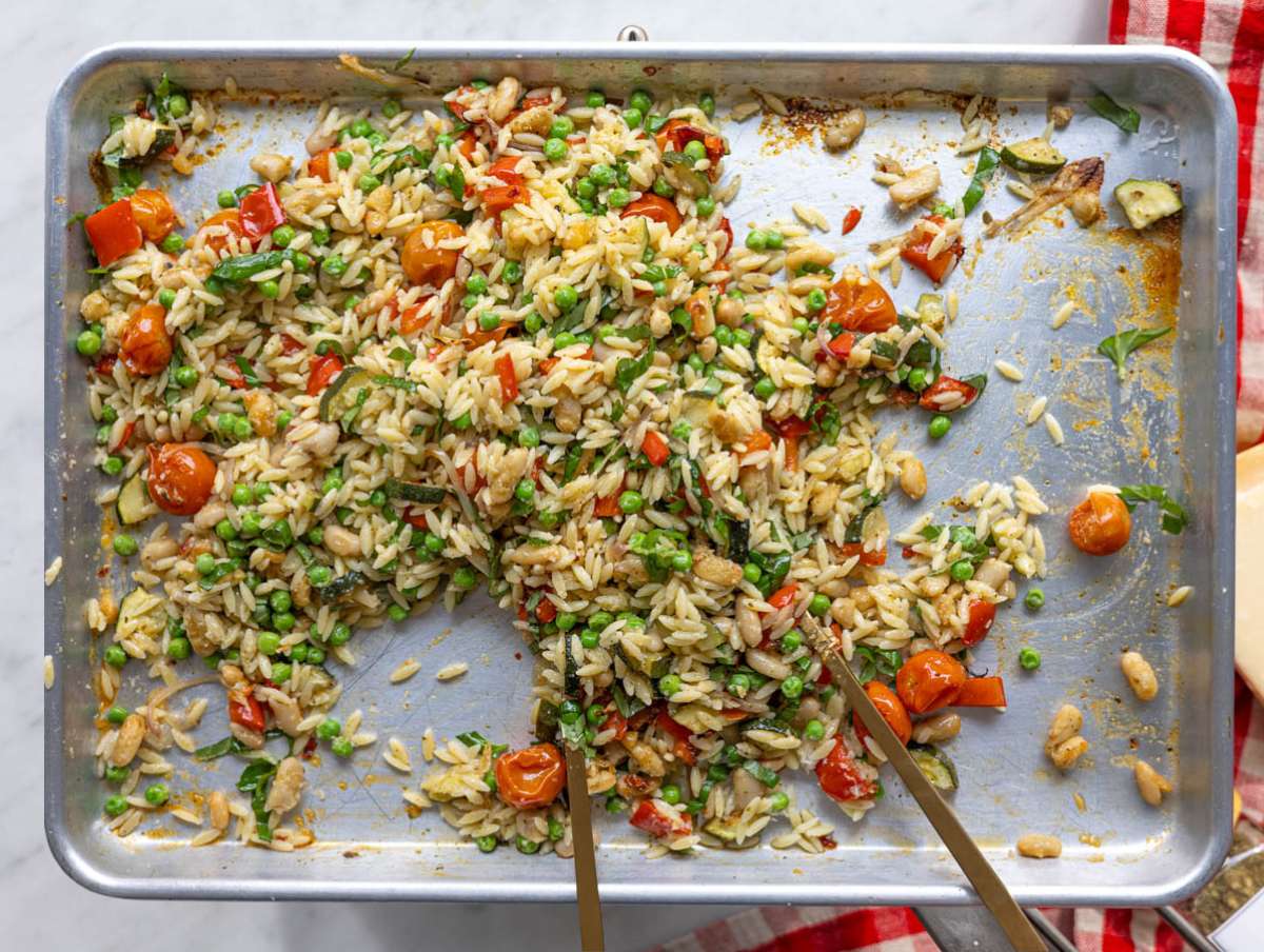 Step 3 Hot orzo added to roasted vegetables on sheet pan with parmesan sprinkled.