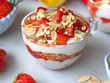 Step 3 Layering yogurt, strawberries, and crunchy topping in glass mug.