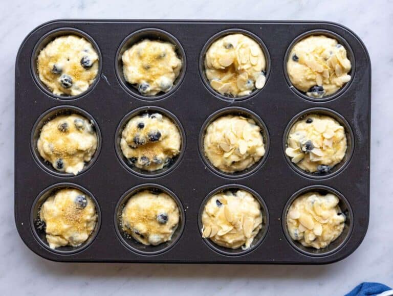 Step 3 Muffin batter scooped into pan with brown sugar topping in bright natural light.