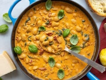 Step 4 Folding Greek yogurt into the beans on marble, finished with fresh basil and lemon zest.