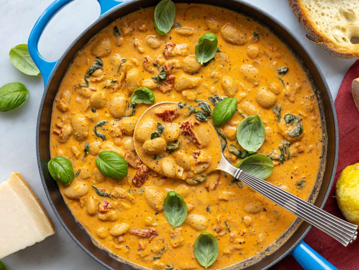 Step 4 Folding Greek yogurt into the beans on marble, finished with fresh basil and lemon zest.