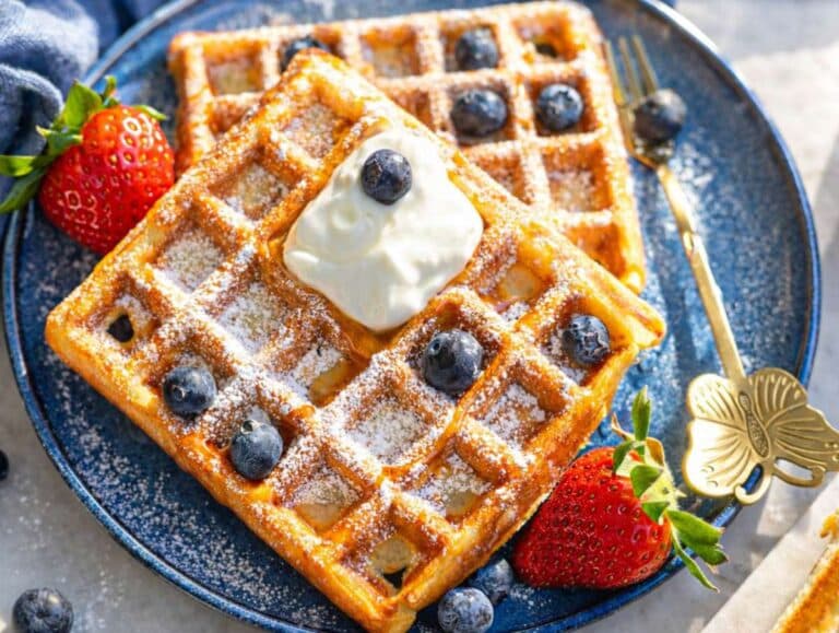 Step 4 Golden waffles stacked neatly with yogurt and honey on marble surface in na.tural light.