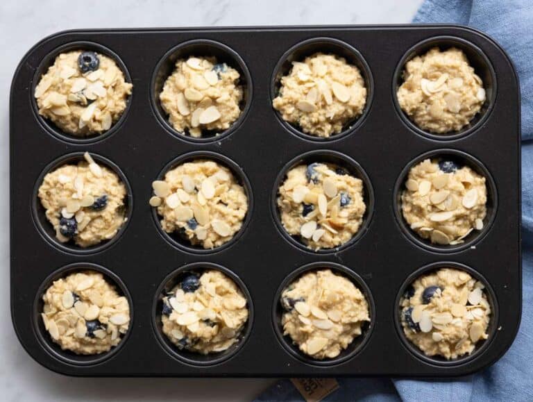 Step 4 Muffin batter with blueberries scooped into a muffin tin.