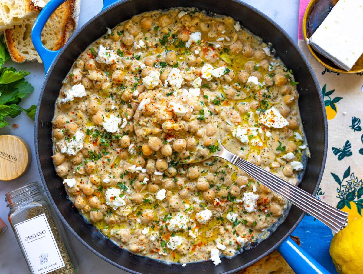 Step 5 Chickpea lemon skillet served with crusty bread on marble table in natural light.