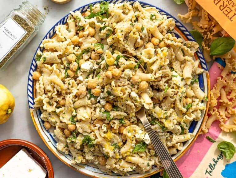 Step 5 Finished lemon pasta salad served on a platter with basil and mint leaves.