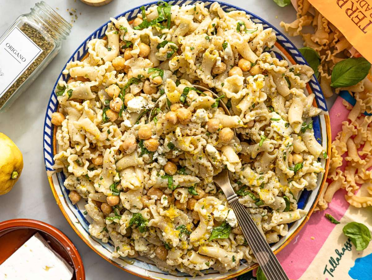 Step 5 Finished lemon pasta salad served on a platter with basil and mint leaves.