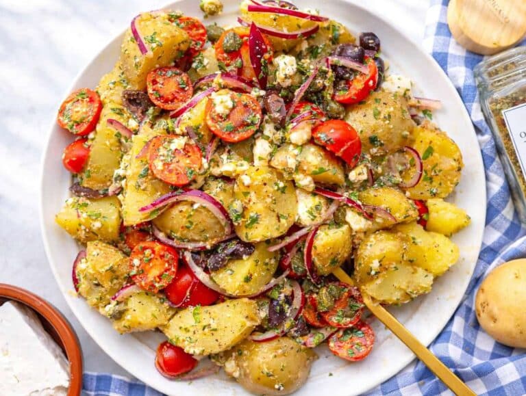 Step 5 Greek potato salad gently tossed and served on a platter with herbs and olive oil drizzle.