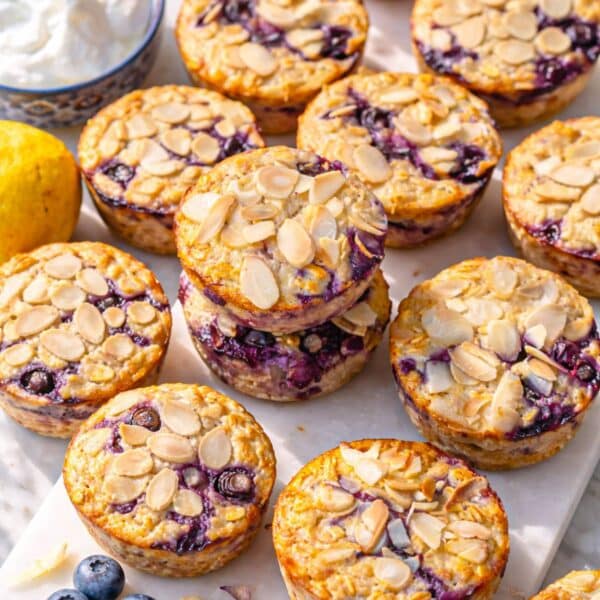 Blueberry baked oatmeal cups arranged neatly on marble table with soft shadows and fresh feel.