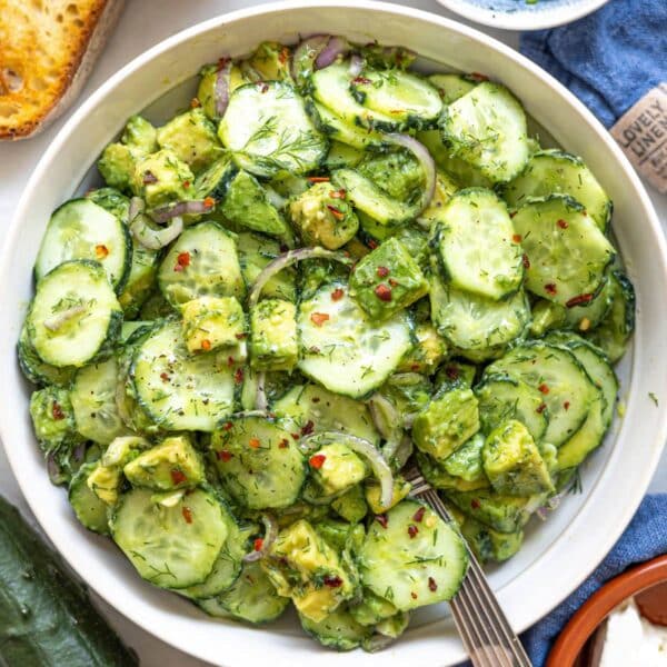 Bowl of cucumber avocado salad with bright colors and soft natural light.