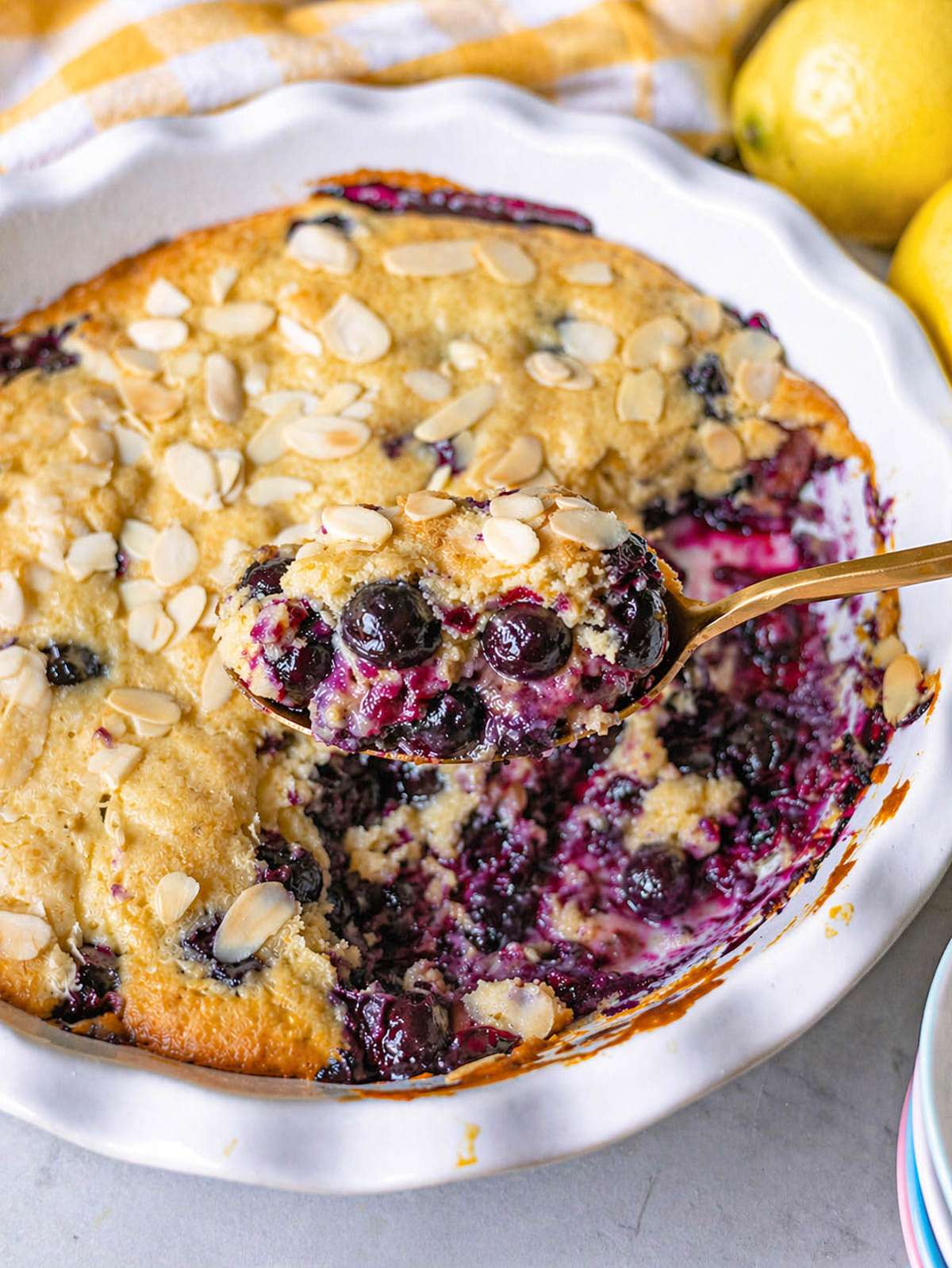 Close-up of blueberry spoon cake showing soft crumb, jammy center, and baked blueberries.