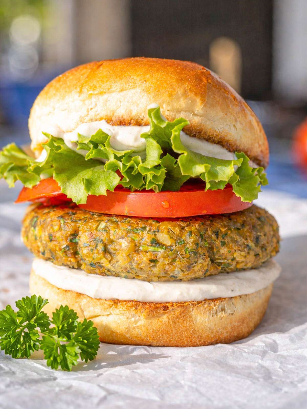 Close-up of falafel burger showing crispy exterior and soft green herb-filled center.