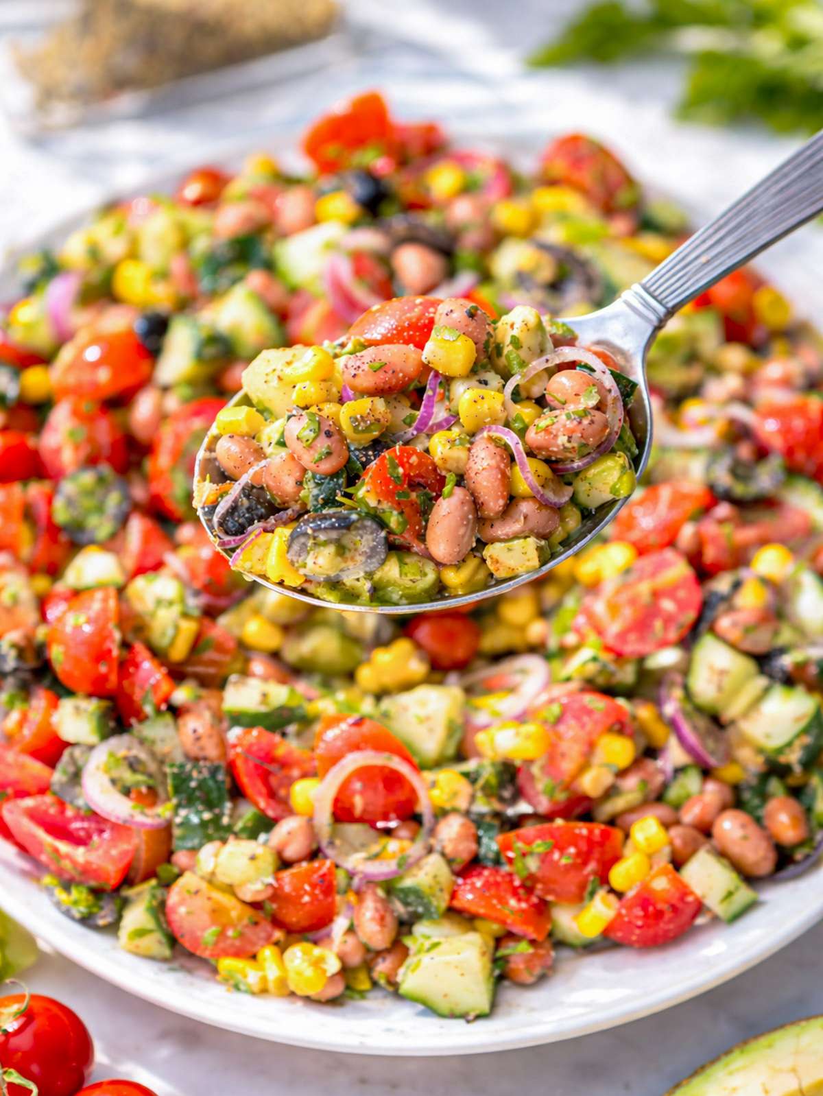 Close up of pinto bean salad showing creamy beans, juicy tomatoes, and fresh parsley.