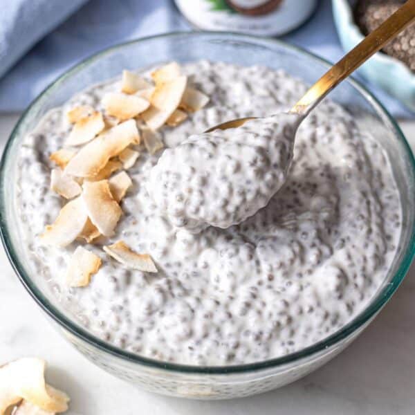 Coconut chia pudding in a breakfast bowl with golden spoon.