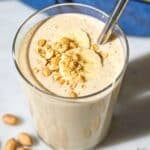 Glass of smoothie on marble counter with soft daylight and minimal styling.