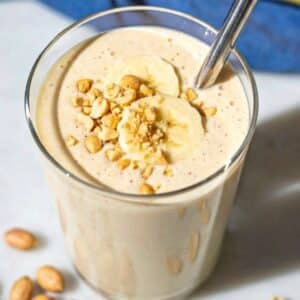 Glass of smoothie on marble counter with soft daylight and minimal styling.