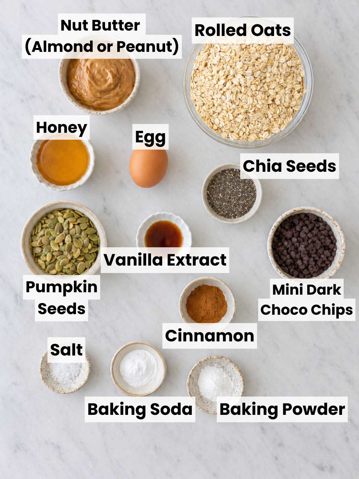 Ingredients for healthy breakfast cookies arranged on marble surface.