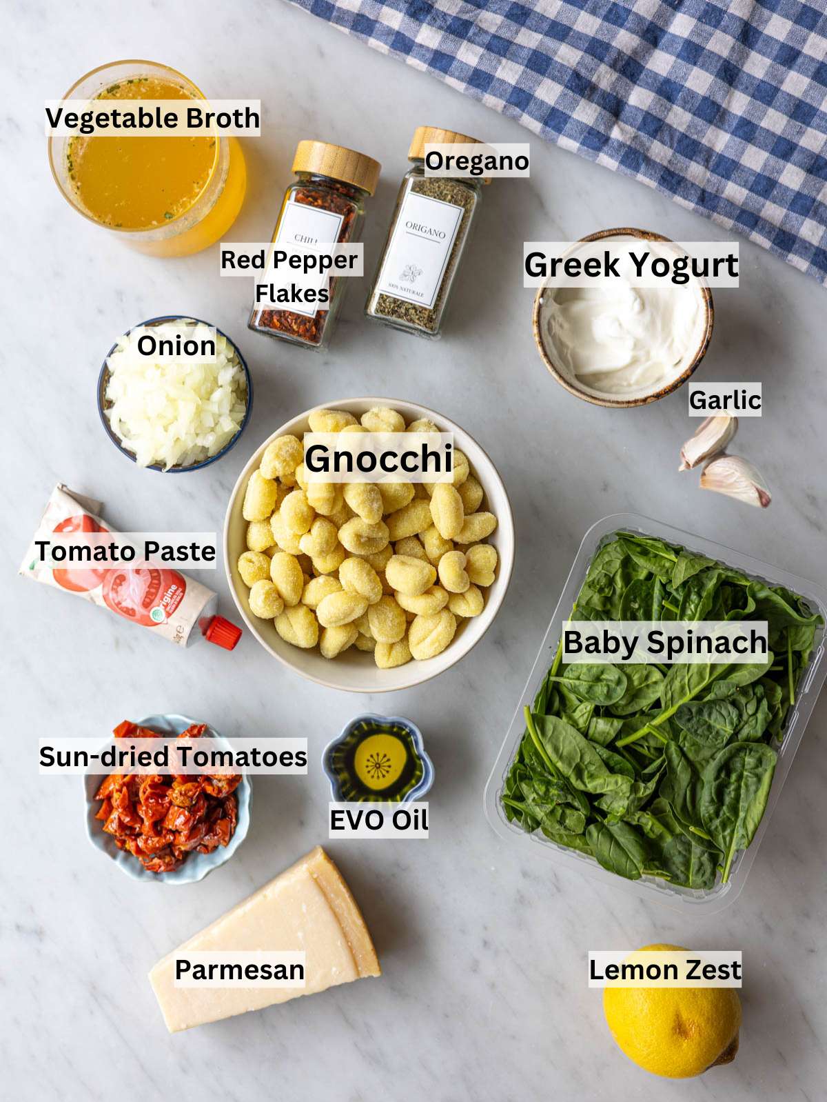 Ingredients for marry me gnocchi arranged in bowls on marble table in natural light.