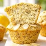 Lemon poppy seed muffins on marble table with soft natural light and fresh lemons.