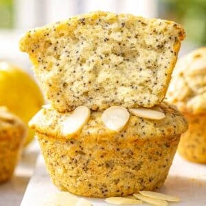 Lemon poppy seed muffins on marble table with soft natural light and fresh lemons.